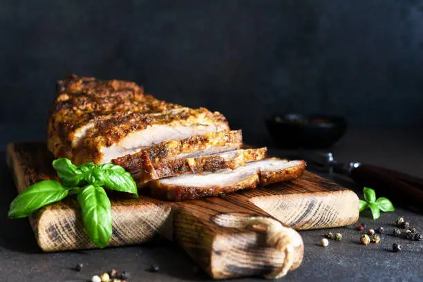 Baked boiled pork.Baked meat slice with garlic and spices on a wooden board.