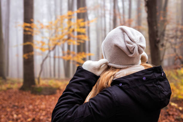 istock Woman pulling knit hat at her ears because freezing during hike in fall season 1338023573