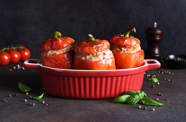 Stuffed pepper. Baked peppers with rice and meat and basil on a dark concrete background. stock photo