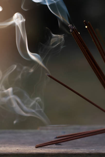 istock Many incense sticks have been lit to perform spiritual practices. Incense smoke and white flowers for open air rituals, religious ceremonies. Meditation, self-knowledge, spirituality. Vertical format. 1338028111