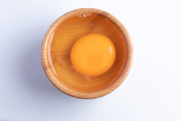 istock raw eggs in a wooden cup on a white background 1338028889