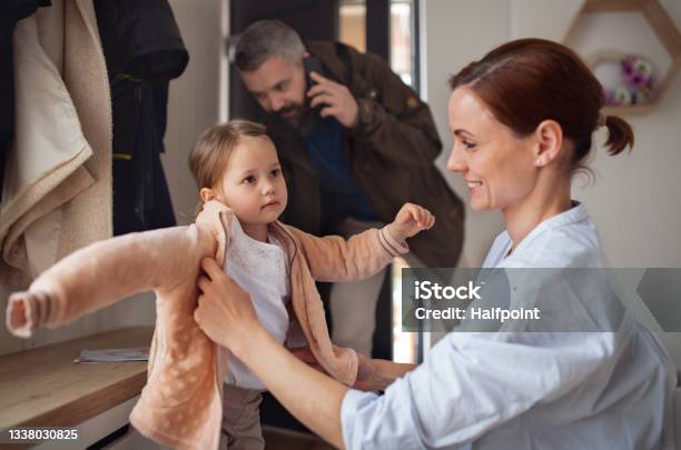 Father And Mother With Small Daughter In Entrance Hall Indoors In The Morning Leaving For Work And Nursery School Stock Photo - Download Image Now