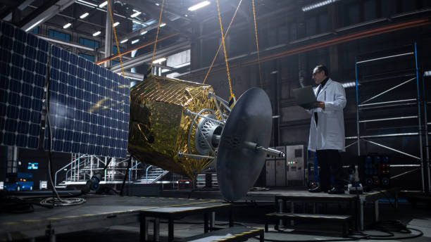 istock Industrial Engineer Working on Artificial Satellite Construction. Aerospace Agency: Scientist Using Laptop Computer to Develop Spacecraft for Space Exploration and Data Communication. 1338031119