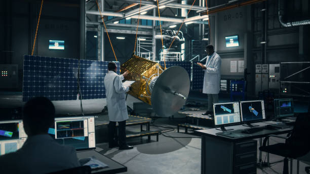 Team of Engineers Working on Satellite Construction. Aerospace Agency Spaceship Manufacturing Factory: Diverse Group of Multi-Ethnic Scientists Developing Spacecraft for International Space Program. equipo de ingenieros que trabajan en la construcción de satélites. fábrica de fabricación de naves espaciales de la agencia aeroespacial: grupo diverso de científicos multiétnicos que desarrollan naves espaciales para el programa espacial internacion