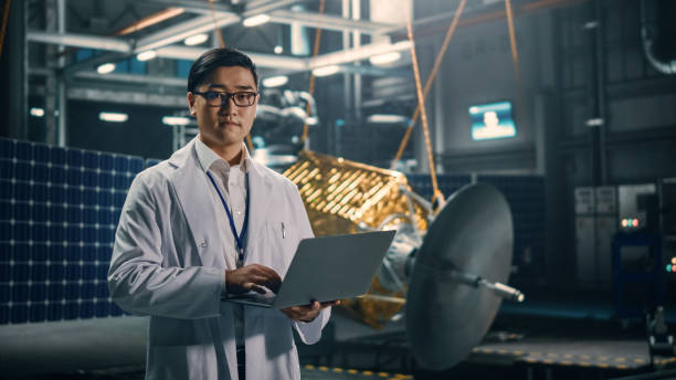 istock Portrait of Serious Asian Engineer Working on Artificial Satellite Construction. Aerospace Agency: Chinese Scientist Using Laptop Computer to Develop Spacecraft for Space Exploration. 1338031884