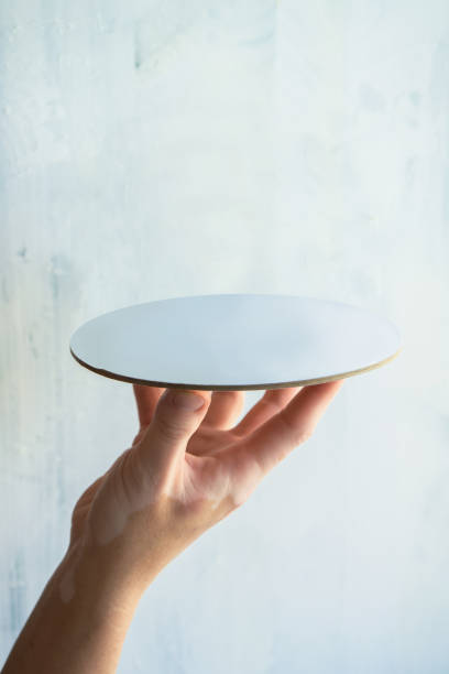 woman's hand holding empty plate with white background product template with space for text and item