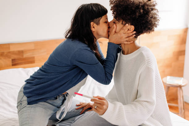 пара празднует положительный тест на беременность дома - lesbian homosexual kissing homosexual couple стоковые фото и изображения