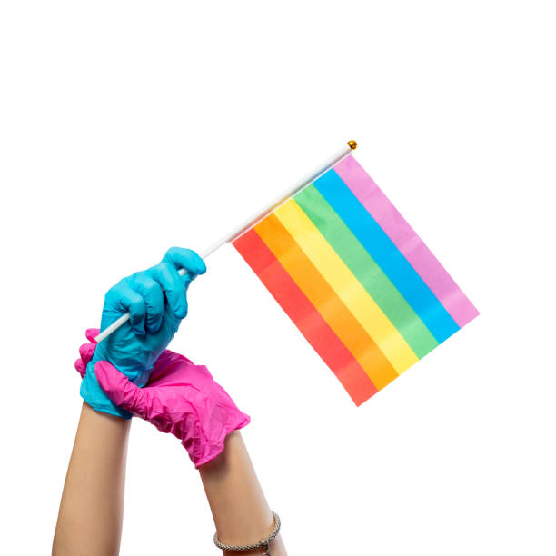 istock LGBT flag hold hands in rubber gloves isolated on white background. Relationship security concept. 1338038703