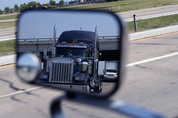 um grande caminhão azul no espelho do veículo - rear view mirror car mirror sun - fotografias e filmes do acervo