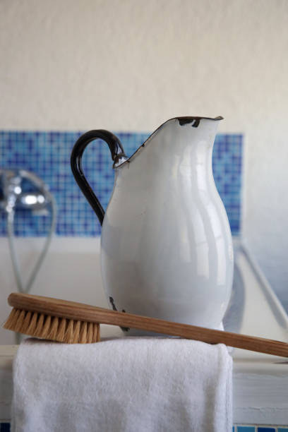 istock Spa bathroom setting: vintage enamel jug, brush and towel. 1338043701