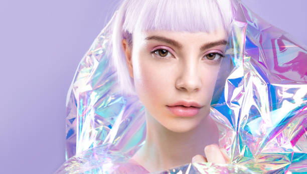 cool sensual young blond girl with ideal brows, purple hair and perfect makeup, healthy glowing skin in colourful iridescent foil - fashion women stage makeup fashion model imagens e fotografias de stock