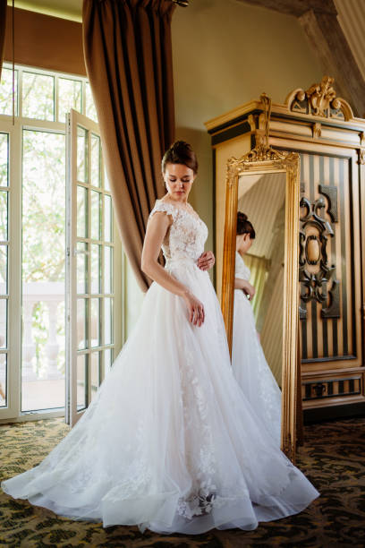 istock the bride at the mirror. selective focus. trying on a wedding dress 1338045033