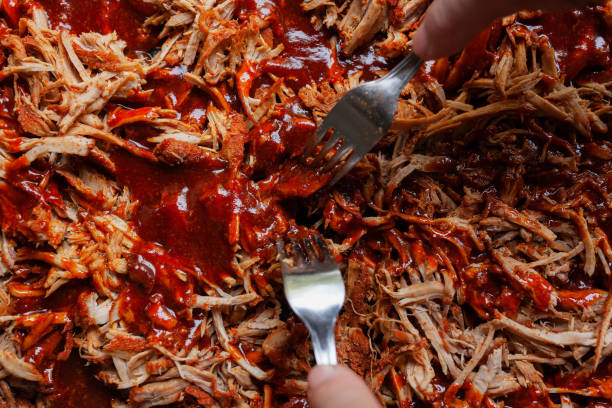 Pulled pork with barbecue sauce with being shredded with two forks Pulled pork with barbecue sauce with being shredded with two forks barbecue pork stock pictures, royalty-free photos & images
