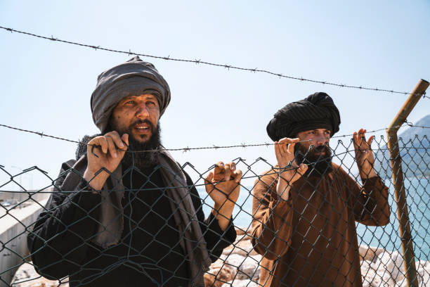 istock Refugee man standing behind the fence 1338050637
