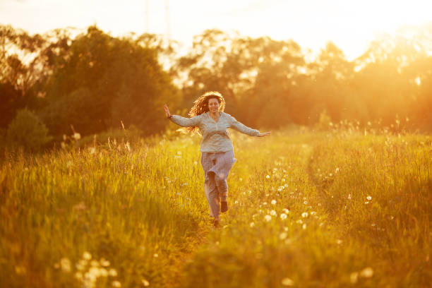 istock Happy girl running through the summer field 1338052182