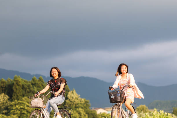 istock Young Asian students enjoying bicycle riding at river side 1338056415