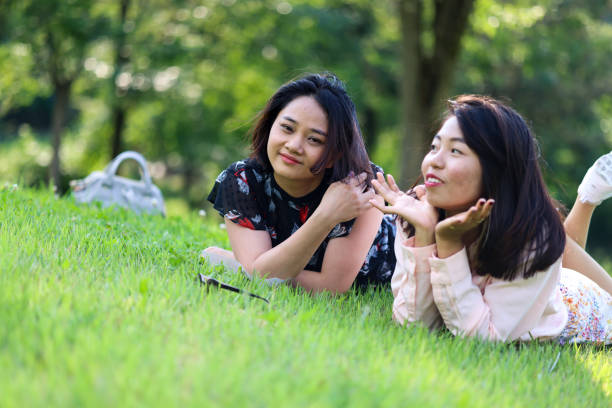 istock Young Asian college students relaxing on grass in campus garden 1338057979