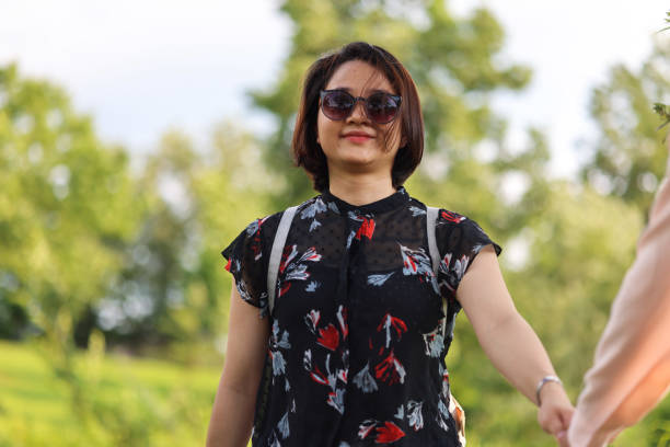 istock Young Asian college students walking in park 1338058267