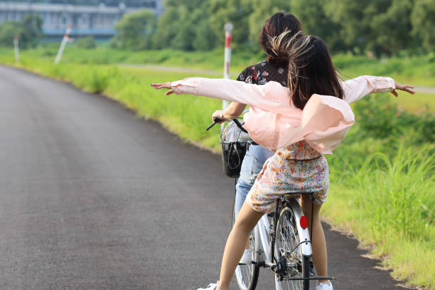 istock Young Asian students enjoying bicycle riding at river side 1338058920