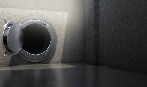 A concept of an open heavy metal walk in bank vault ina concret chamber spotlit by an overhead light - 3D render
