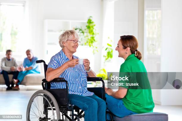 Senior Woman Talking With Nurse In Retirement House Stock Photo - Download Image Now