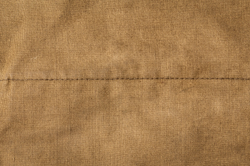 Texture of army rough khaki fabric with seam and dark vignette. Template for design and site header