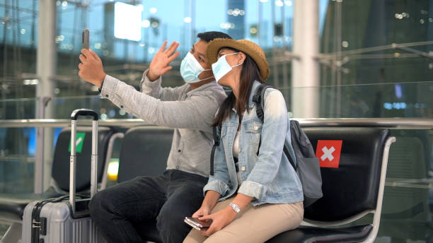 Couple traveler sitting and relax in the terminal airport stock photo