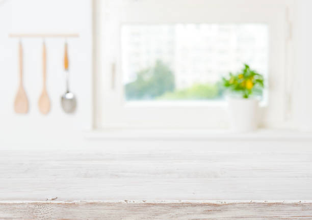 istock Blurred kitchen window sill background and vintage wooden table space 1338064043