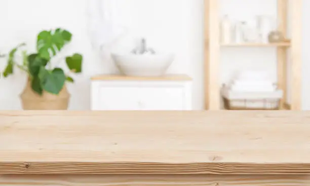 Empty wooden table top and blurred bathroom interior as background