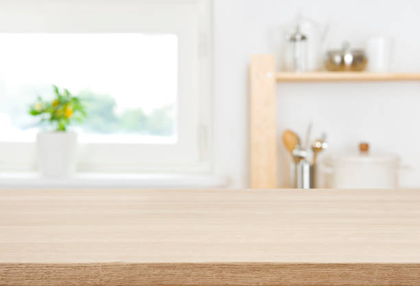 istock Wood table top with blur kitchen window and shelves background 1338064146