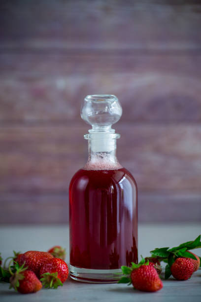 sweet cooked strawberry syrup in a glass decanter stock photo