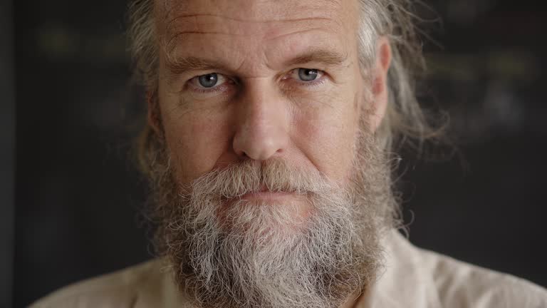 Close up portrait of a handsome middle-aged man looking at camera with an intense gaze. Lifestyle concept, achievement, father, grandfather.