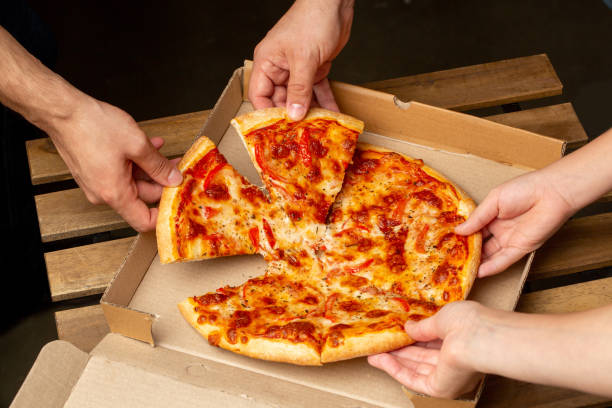 istock Pizza delivery to home, hands pull peace of pizza 1338068102