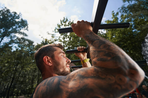 istock Muscular tattoed man doing pull ups outdoors 1338069647