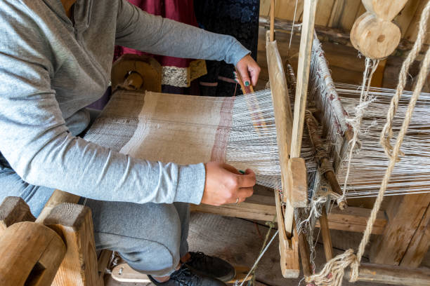 istock A woman weaver makes fabric on an old hand loom. 1338070080