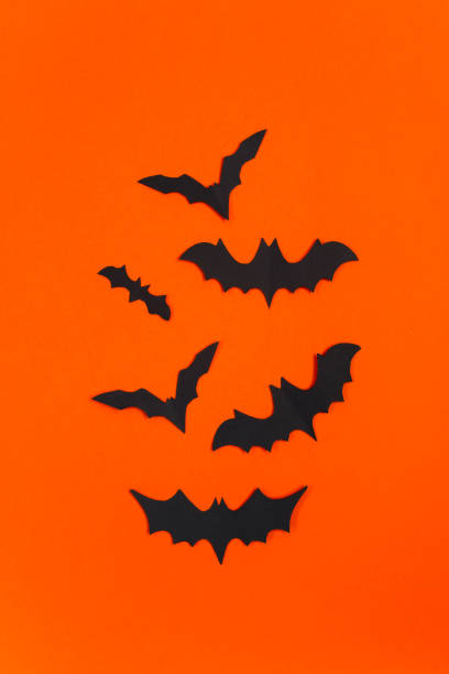 istock Halloween concept. Festive decorations. Bats on orange background. 1338072468