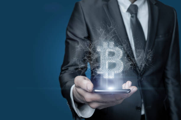 istock Businessman shows on the phone Bitcoin on blue background. 1338073640
