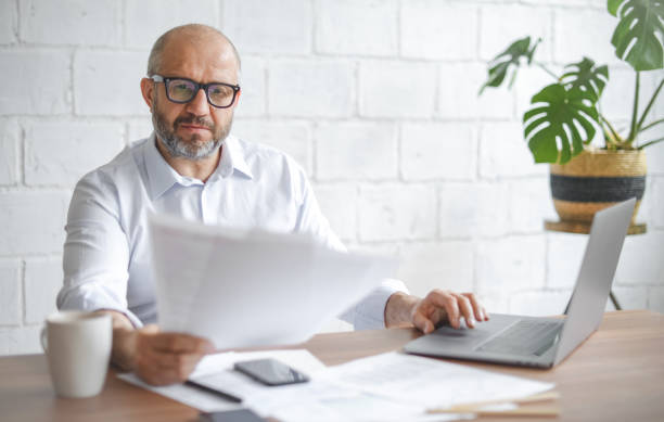 istock mature adult man working from office ( with laptop,paperwork) 1338073776