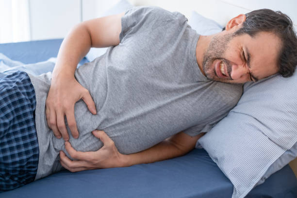 Man in bed suffering from heartburn and stomach pain One man suffering stomachache in the morning intestinal tract infection stock pictures, royalty-free photos & images