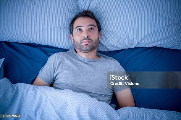 Anxious Man Trying To Sleep But Suffering Insomnia Stock Photo - Download Image Now - Insomnia, Bed - Furniture, Sleep Apnea