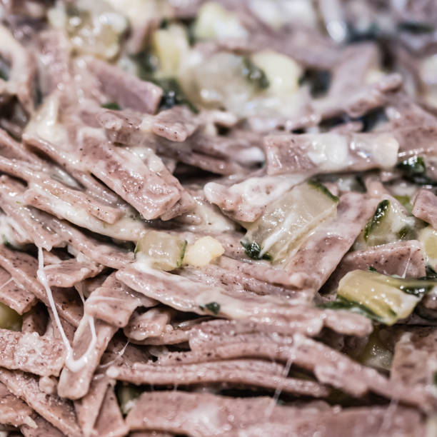 very close up of the succulent and typical italian dish pizzoccheri in a white plate on a table. typical dish from valtellina, lombardy, italy. - pizzoccheri homemade tagliatelle italy imagens e fotografias de stock