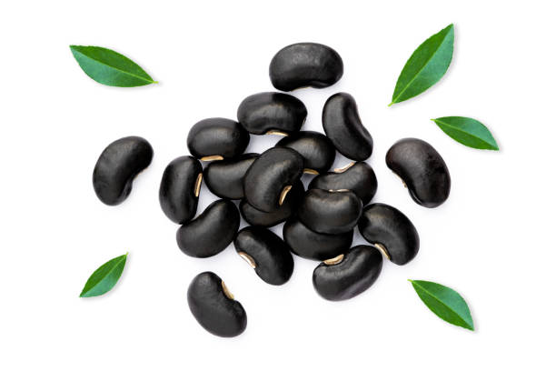 istock Black beans with green leaves isolated on white background . 1338075813