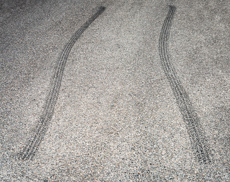 Close-up of a curving set of tire marks on a street.