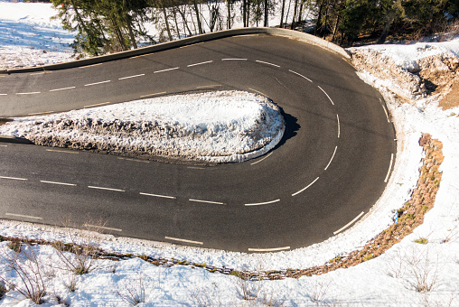 A tight hairpin curve on a mountain highway in the French Alps.