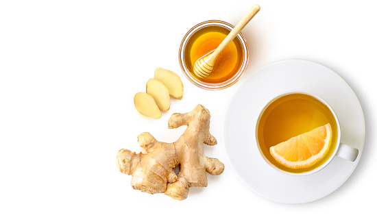 Ginger tea with ginger root and honey on white background. Top view. Flat lay. Copy space.