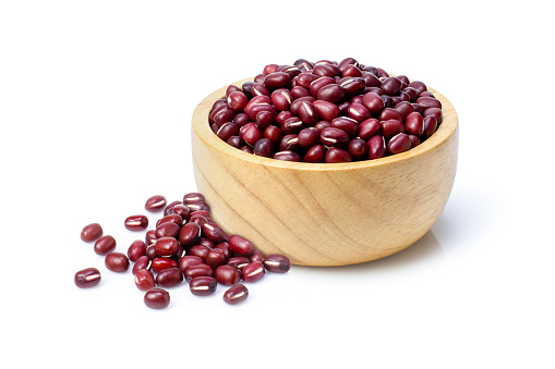 Closeup red Azuki beans (Adzuki or japanese red bean) in wooden bowl isolated on white background.