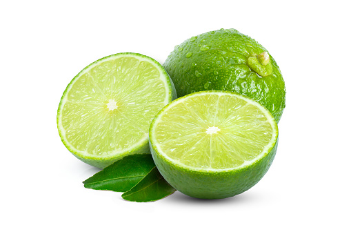 Fresh group of halved cut green limes on plate.