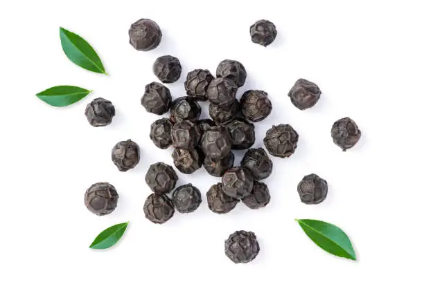 Pile of black pepper (peppercorns) with green leaf isolated on white background. Top view. Flat lay.