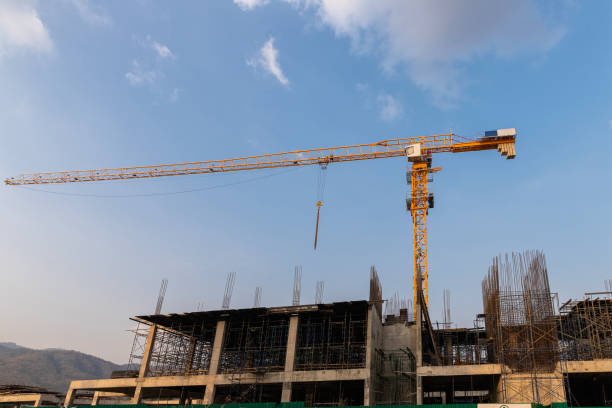 istock Yellow tower crane and building under construction against blue sky. Industry concept. 1338081162