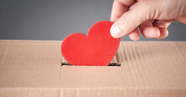 istock Male hand putting red heart in box. 1338085365